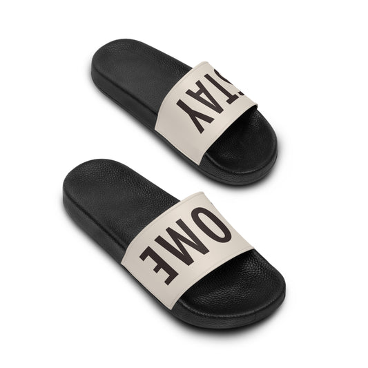 Stay Home Slides in black with a cream strap, angled view of the pair showing the STAY HOME text