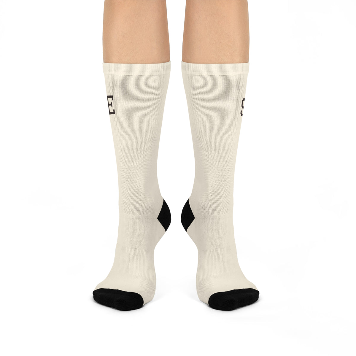 Front view of the Stay Home Socks in ivory with black toe blocking, worn on both feet