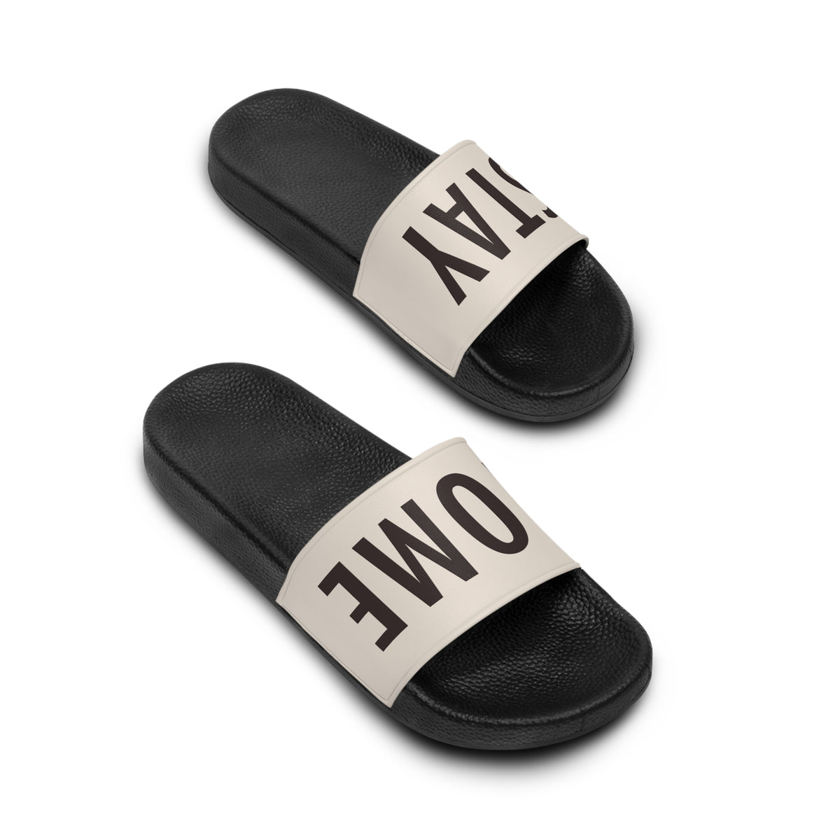 Stay Home Slides in black with a cream strap, angled view of the pair showing the STAY HOME text